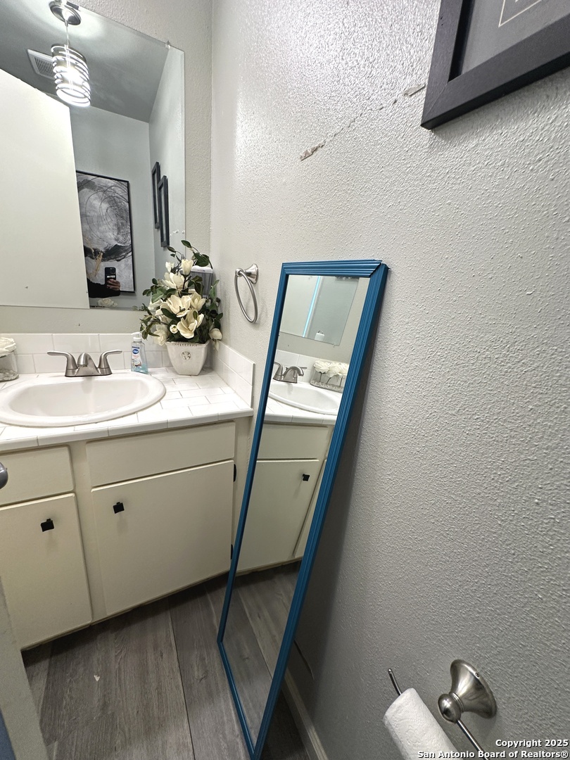 911 Vance Jackson Road, Unit Y San Antonio, TX 78201 - Photo 23 of 40 a bathroom with a sink a mirror and vanity