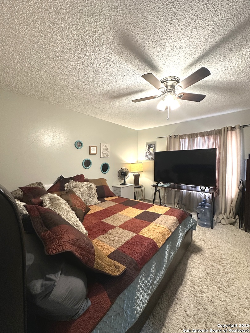 911 Vance Jackson Road, Unit Y San Antonio, TX 78201 - Photo 33 of 40 a spacious bedroom with a bed and a flat screen tv
