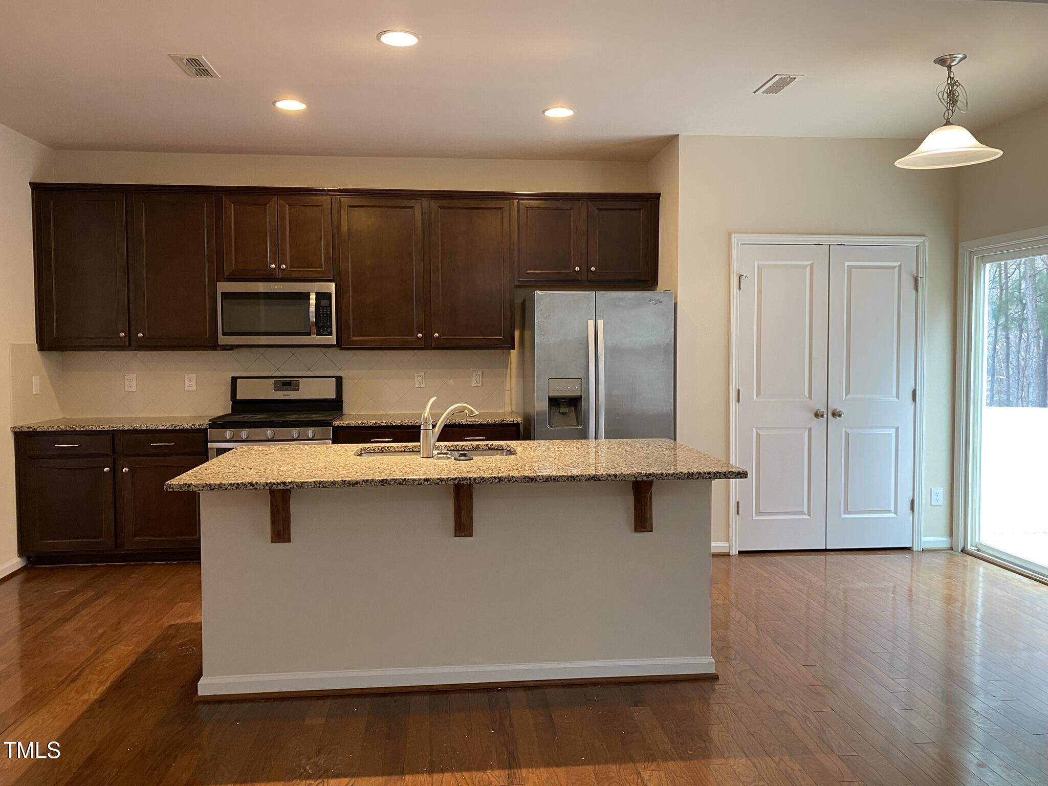 3545 Massey Ridge Court Raleigh, NC 27616 - Photo 9 of 38 a kitchen with stainless steel appliances a sink a stove a refrigerator cabinets and wooden floor