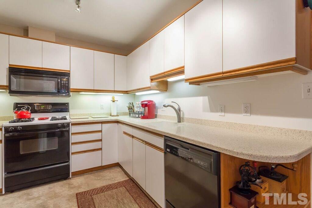 2903 Buckingham Road Durham, NC 27707 - Photo 6 of 15 a kitchen with granite countertop a sink stainless steel appliances and cabinets