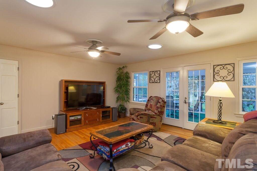 2903 Buckingham Road Durham, NC 27707 - Photo 8 of 15 a living room with furniture a chandelier and a flat screen tv