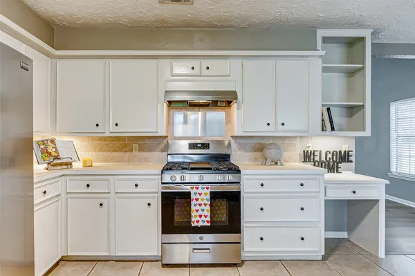 a kitchen with stainless steel appliances granite countertop a stove and white cabinets