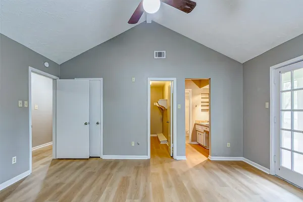 a view of an empty room with window and bathroom