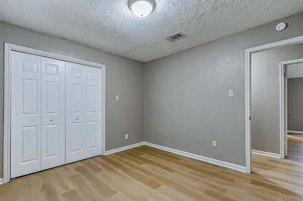 a view of empty room with wooden floor