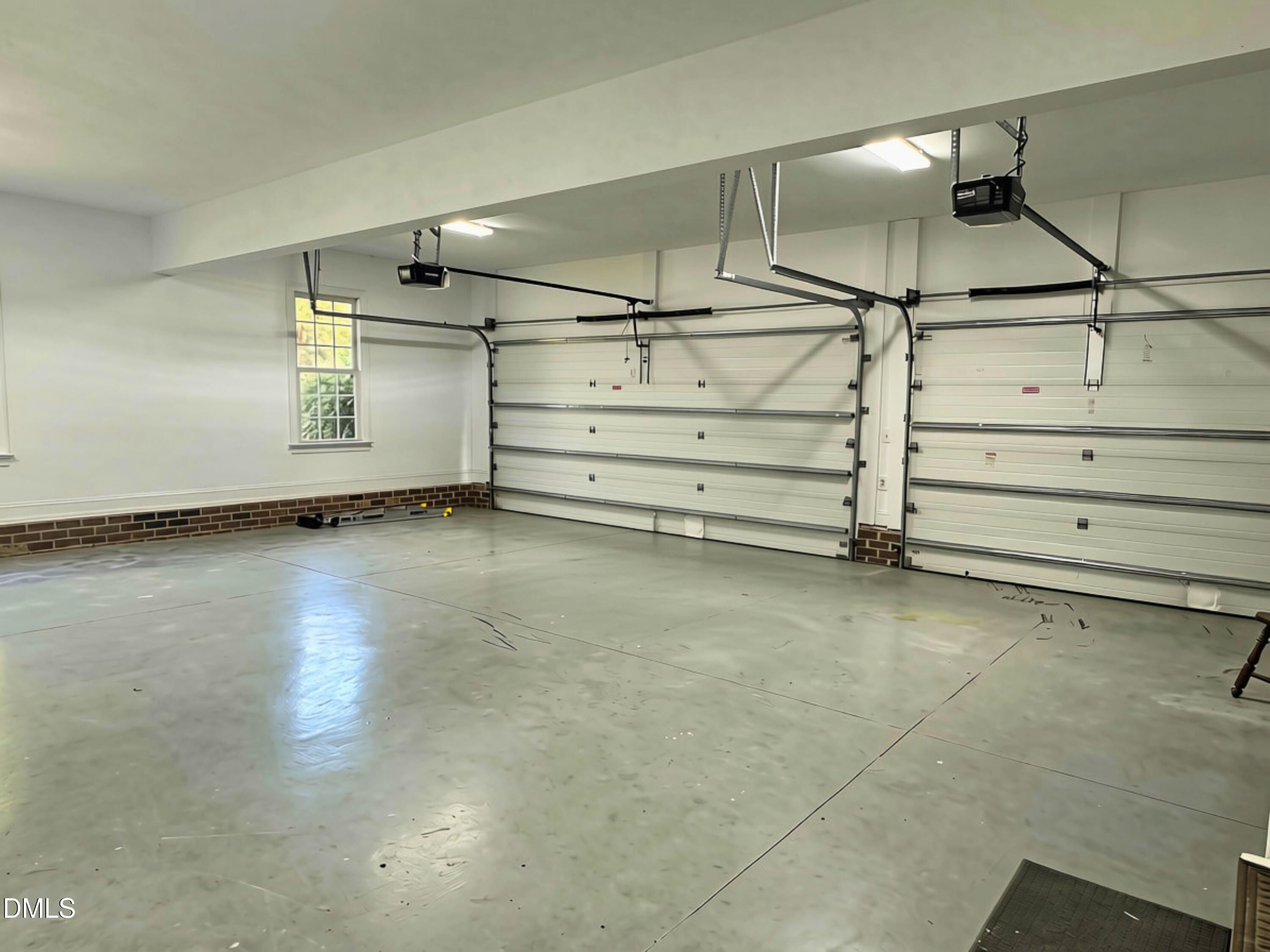 3100 Donlin Drive Wake Forest, NC 27587 - Photo 56 of 67 Spacious garage with concrete flooring, two overhead doors, and brick wainscoting