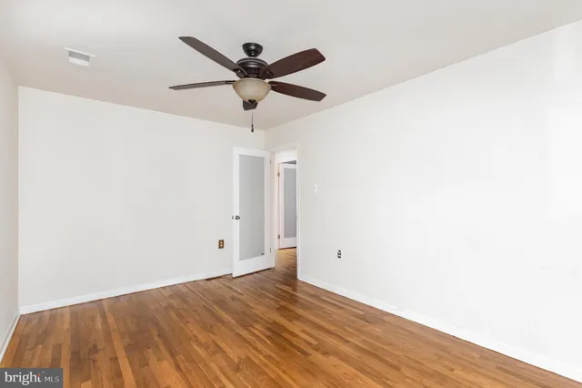 a view of a big room with wooden floor and a ceiling fan