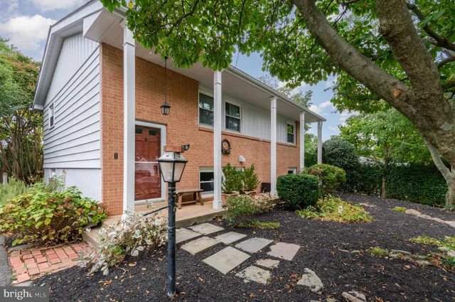 a view of a white house with a yard and plants