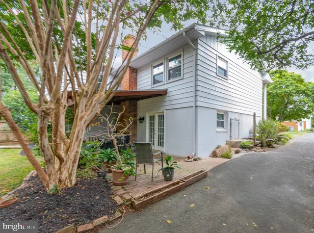 a view of a house with a tree and sitting area