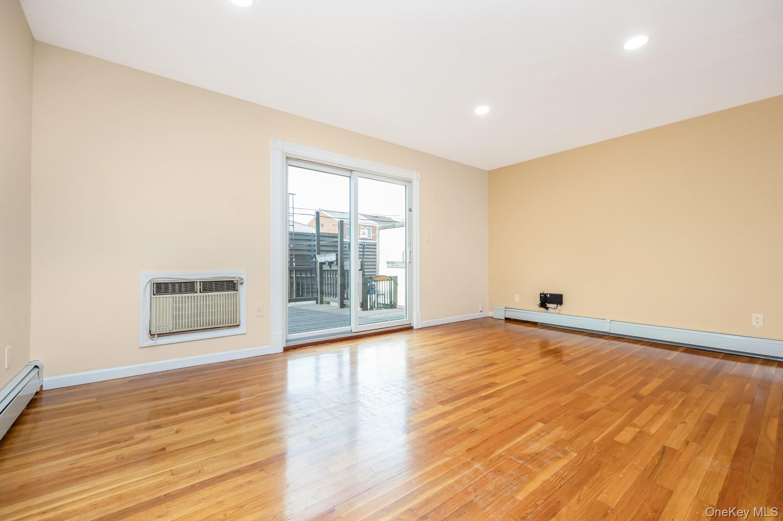 69-05 61st Road Queens, NY 11379 - Photo 11 of 31 a view of an empty room with wooden floor and a window