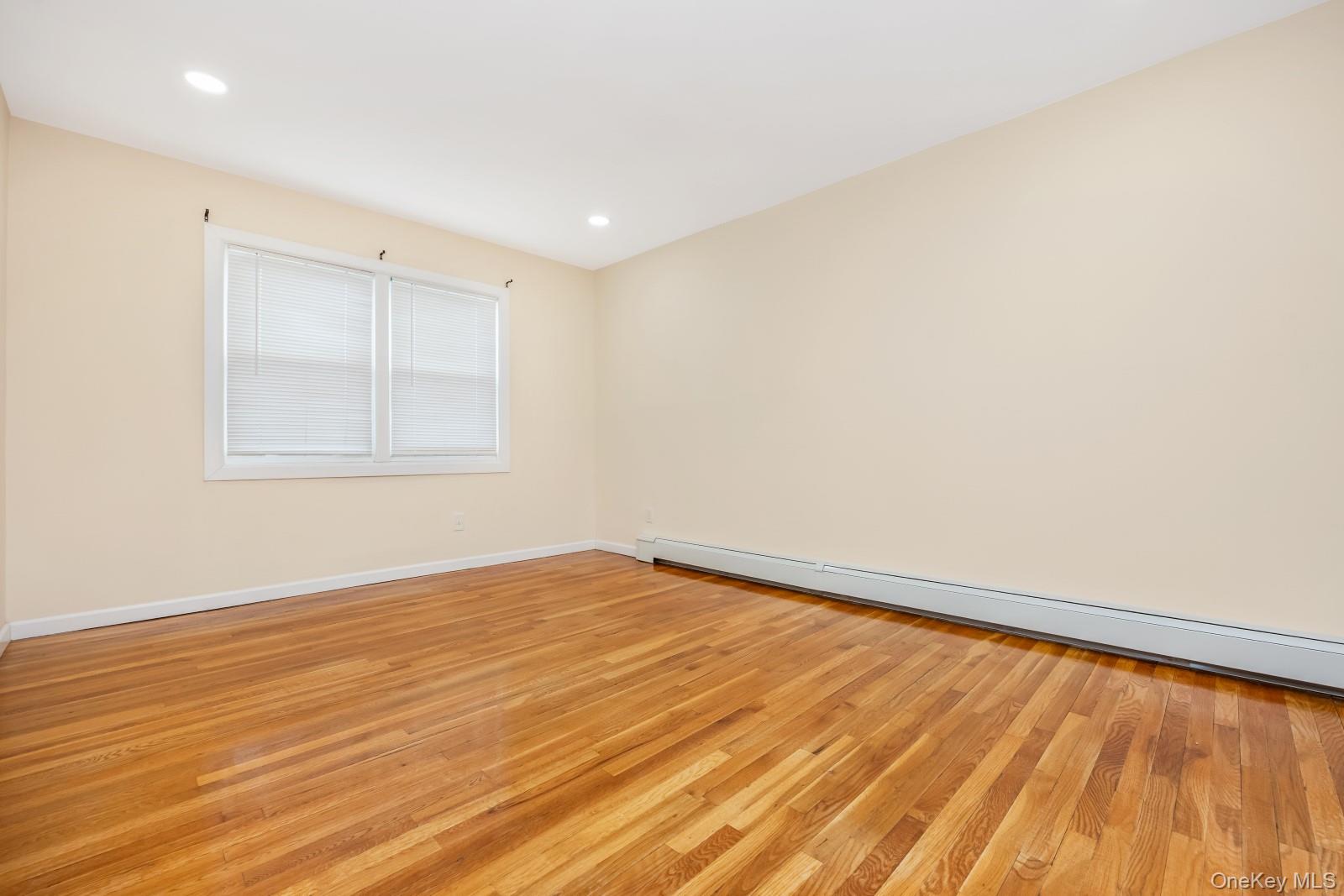 69-05 61st Road Queens, NY 11379 - Photo 20 of 31 an empty room with wooden floor and windows