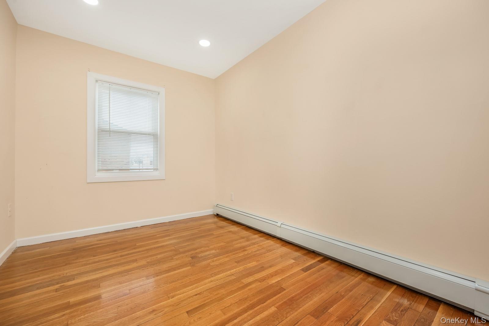 69-05 61st Road Queens, NY 11379 - Photo 22 of 31 an empty room with wooden floor and windows