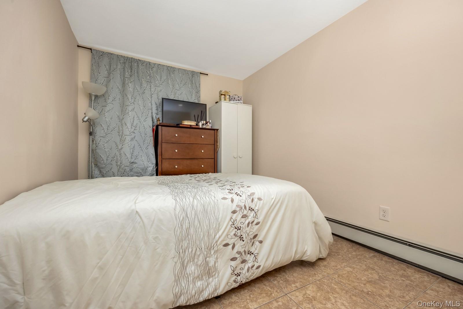 69-05 61st Road Queens, NY 11379 - Photo 28 of 31 a bedroom with a bed and a wall painting