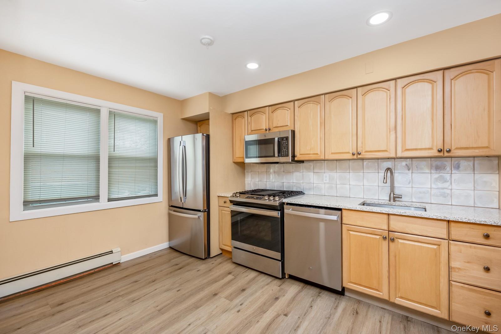 69-05 61st Road Queens, NY 11379 - Photo 4 of 31 a kitchen with stainless steel appliances granite countertop a stove a sink and a refrigerator
