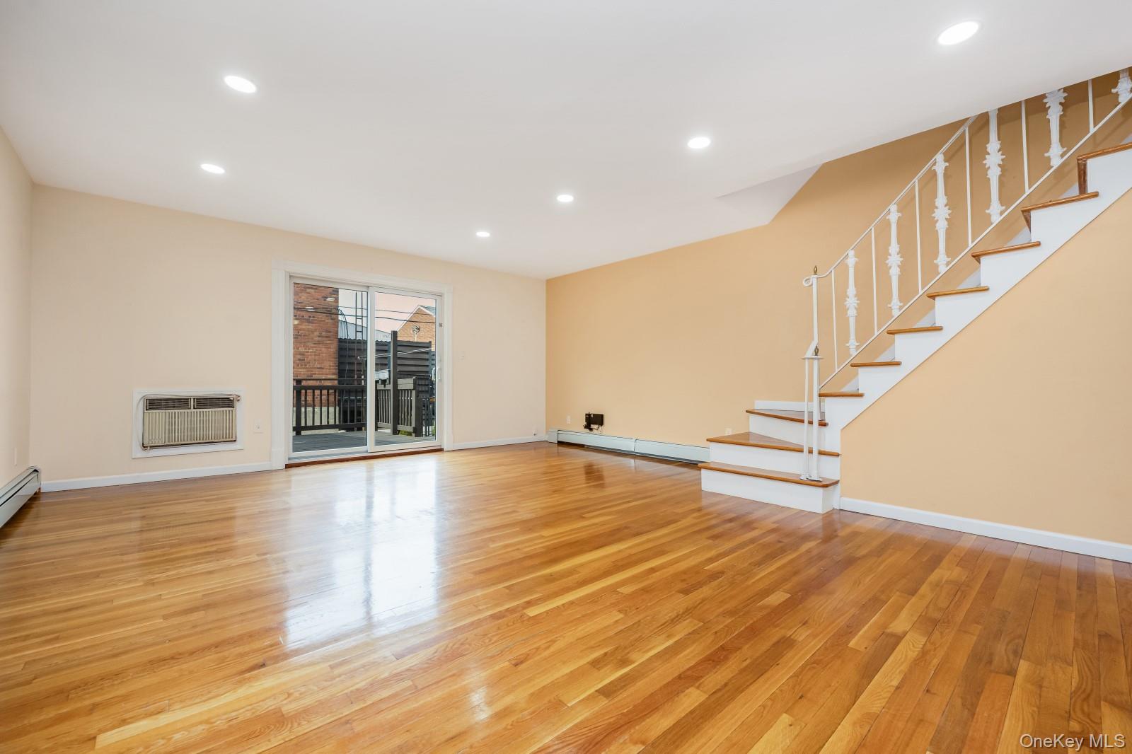 69-05 61st Road Queens, NY 11379 - Photo 6 of 31 a view of an empty room with wooden floor and stairs