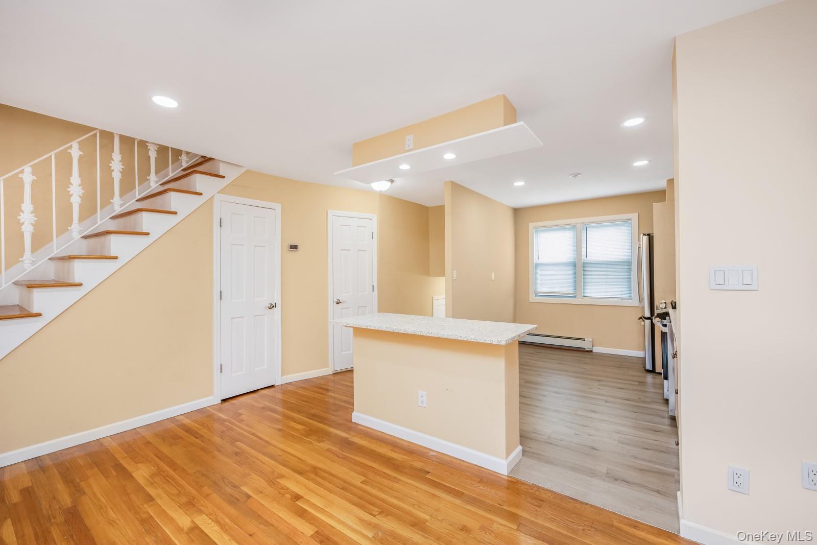 69-05 61st Road Queens, NY 11379 - Photo 7 of 31 a view of an empty room with wooden floor and stairs