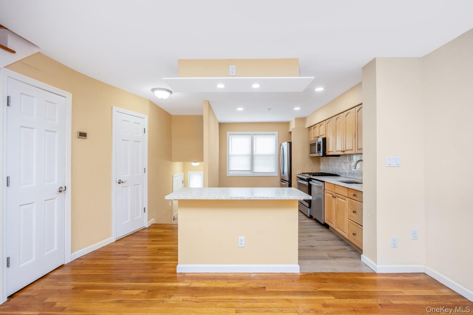 69-05 61st Road Queens, NY 11379 - Photo 9 of 31 a large kitchen with stainless steel appliances granite countertop a stove and a refrigerator
