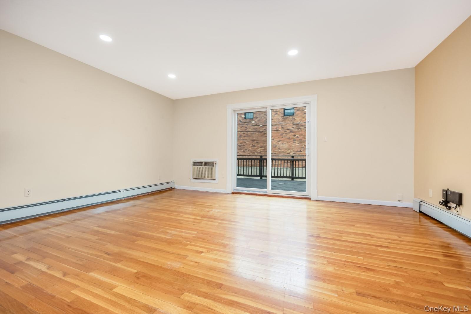 69-05 61st Road Queens, NY 11379 - Photo 10 of 31 a view of an empty room with wooden floor and a window