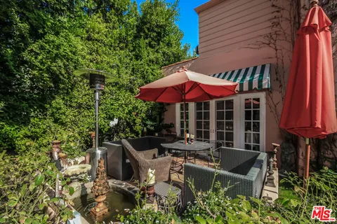 an outdoor sitting area with furniture and umbrella