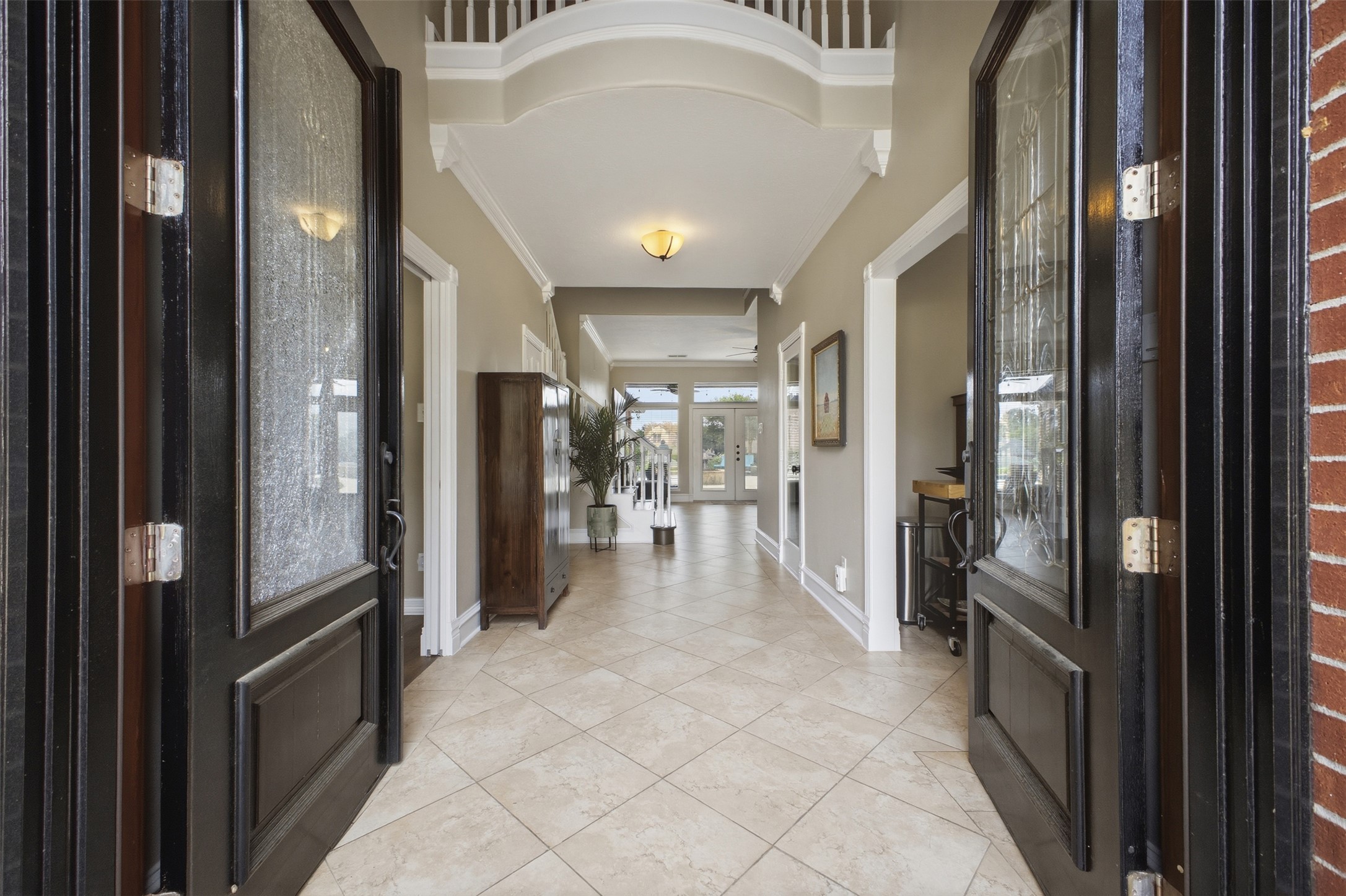 12710 Aries Loop Willis, TX 77318 - Photo 2 of 40 The property features a grand entryway with double doors, leading to a hallway with tiled flooring