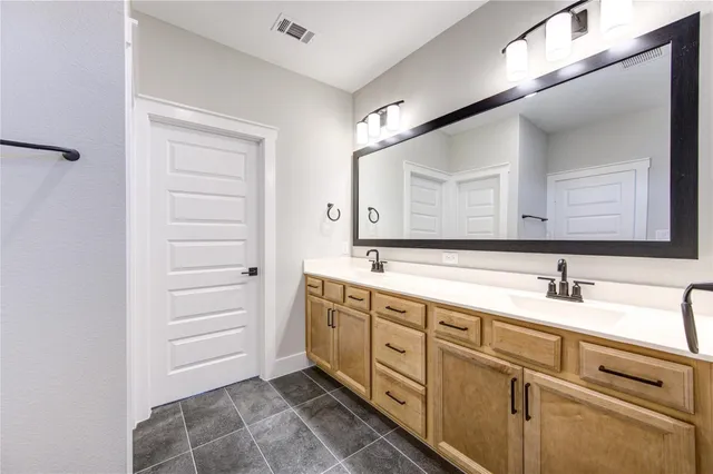 a spacious bathroom with a double vanity sink a mirror and a