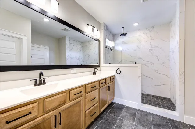 a spacious bathroom with double vanity and a mirror