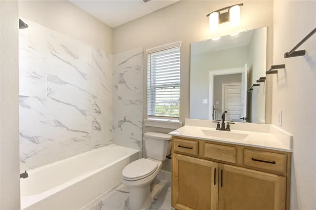 a bathroom with a sink toilet vanity tub and shower