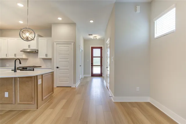 a large kitchen with a sink stainless steel appliances and cabinets