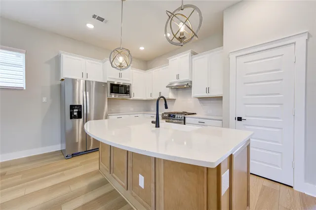 a kitchen with a sink a counter space and stainless steel appliances