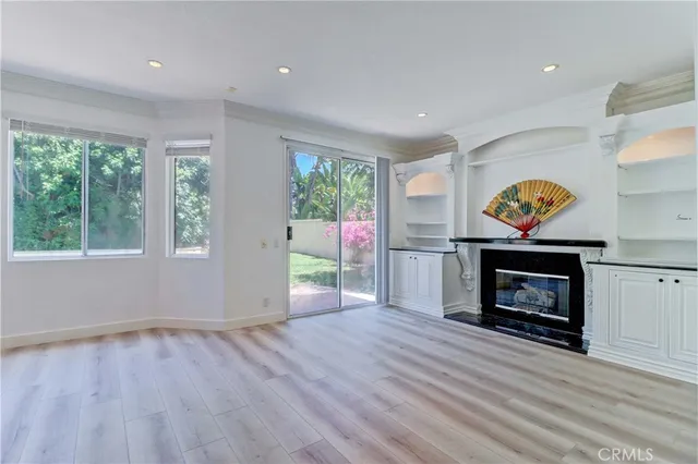 an entryway and an livingroom with fireplace wooden floor and windows