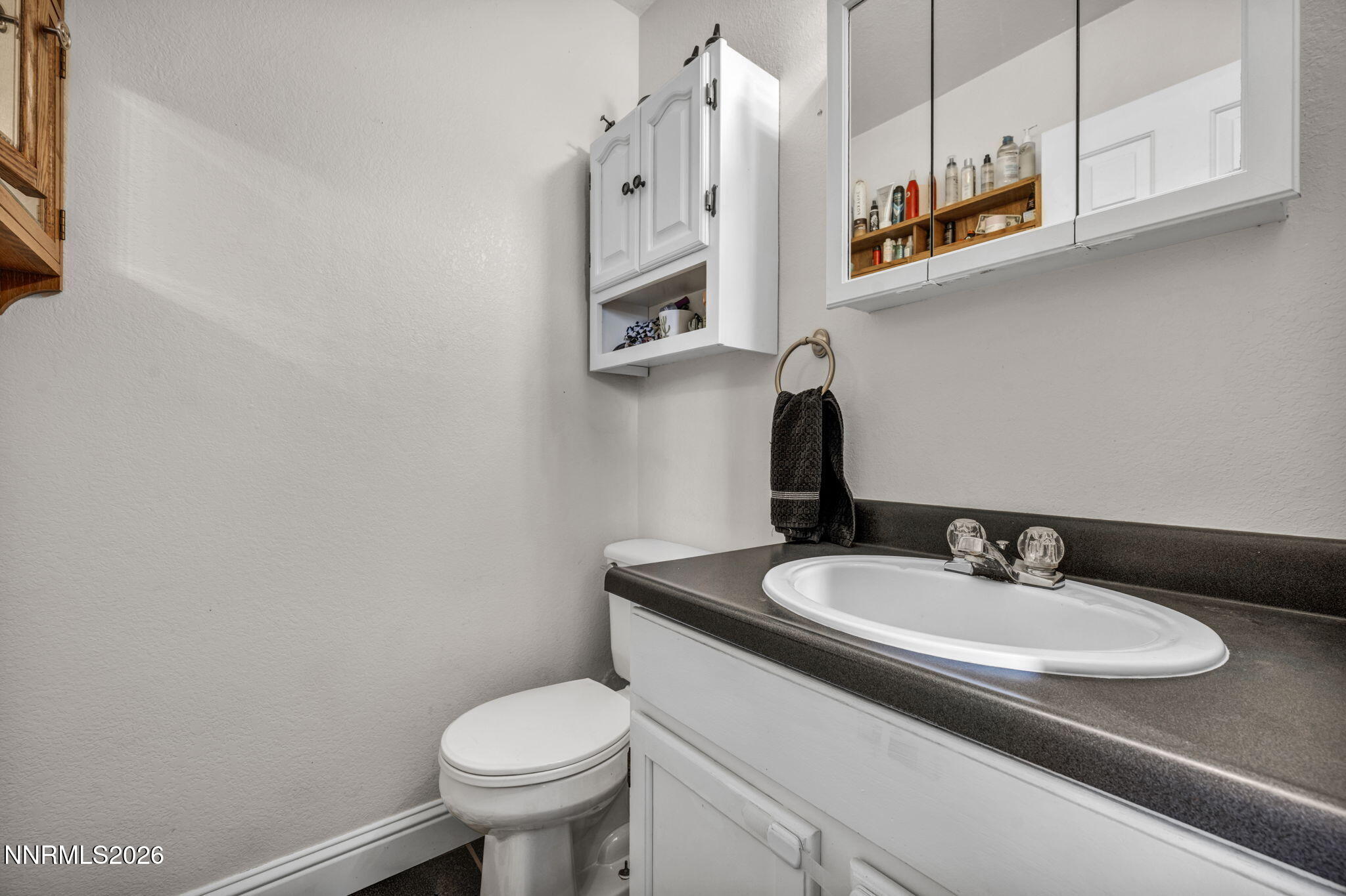 55 Buckboard Circle Reno, NV 89508 - Photo 16 of 39 a bathroom with a granite countertop toilet sink and mirror
