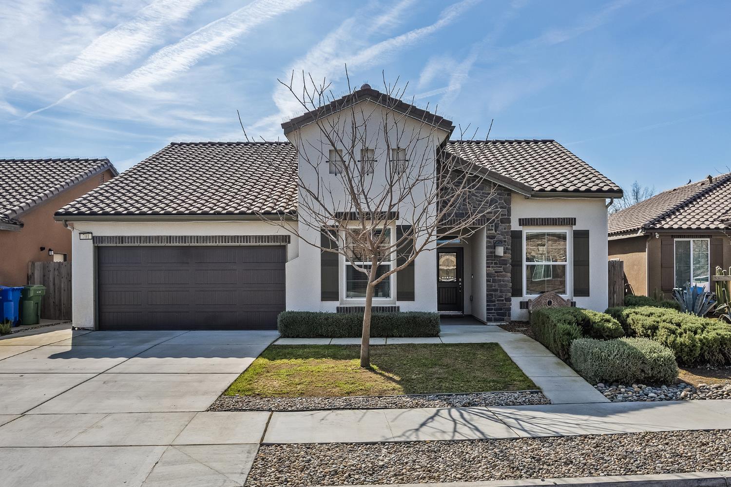 701 Strada Street Lemoore, CA 93245 - Photo 1 of 25 a front view of a house with garden