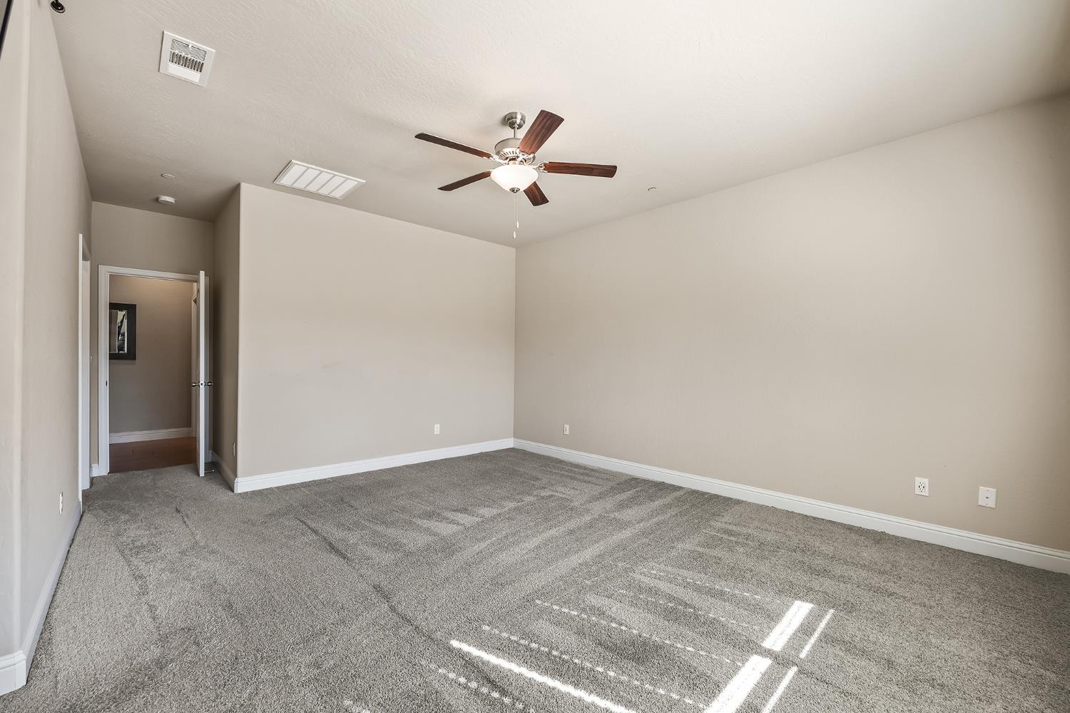 701 Strada Street Lemoore, CA 93245 - Photo 13 of 25 an empty room with closet and a ceiling fan