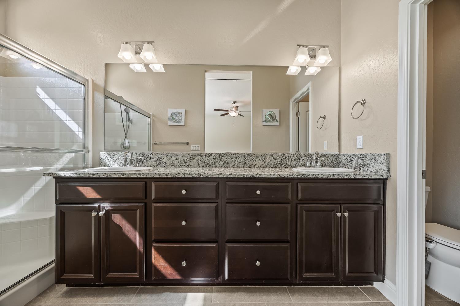 701 Strada Street Lemoore, CA 93245 - Photo 14 of 25 a bathroom with a sink and a large mirror