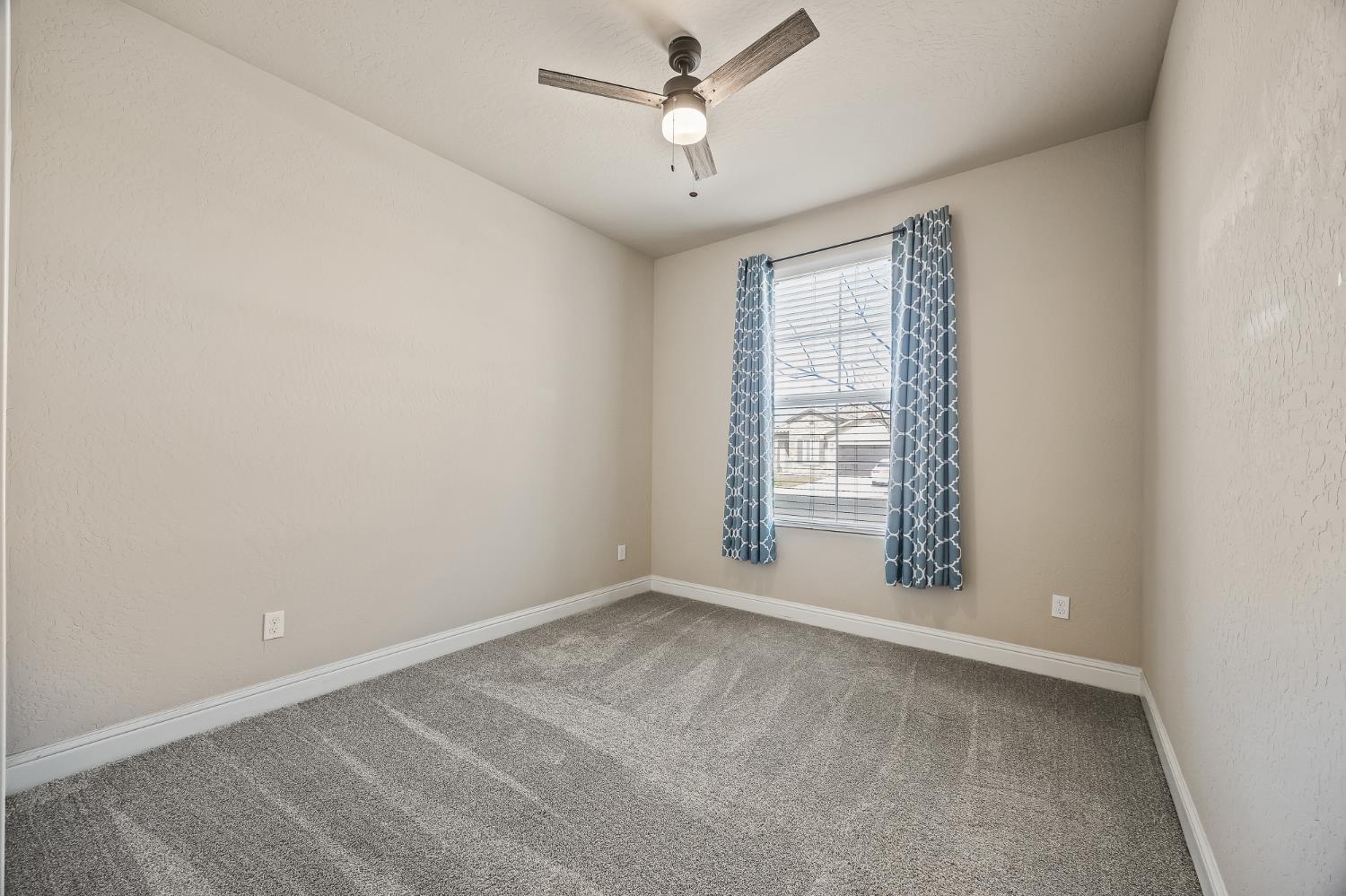 701 Strada Street Lemoore, CA 93245 - Photo 18 of 25 an empty room with a window and ceiling fan