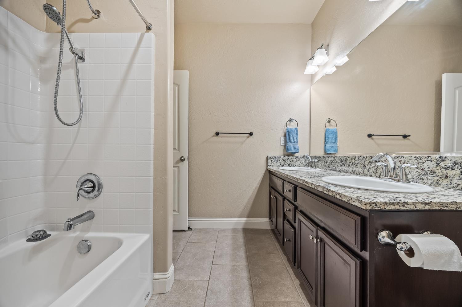 701 Strada Street Lemoore, CA 93245 - Photo 20 of 25 a bathroom with a granite countertop sink a toilet and shower