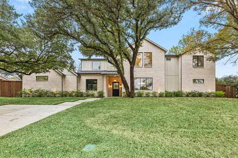 a front view of house with yard and trees