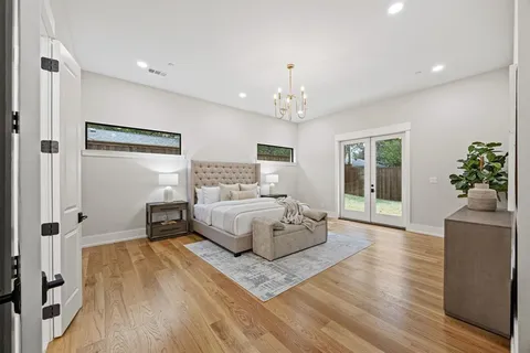 a spacious bedroom with a large bed and a chandelier