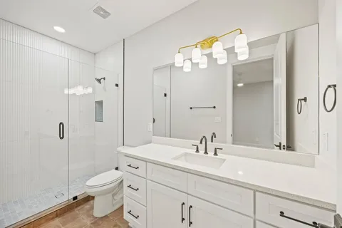 a bathroom with a sink a toilet and shower