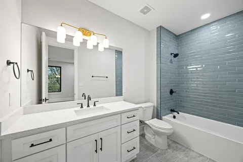 a bathroom with a double vanity sink mirror and toilet