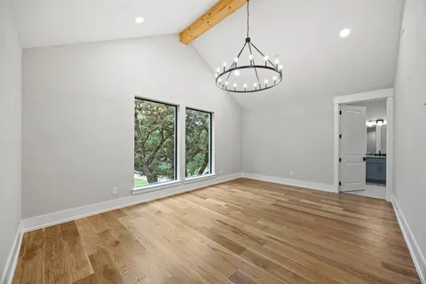 a view of empty room with wooden floor and window