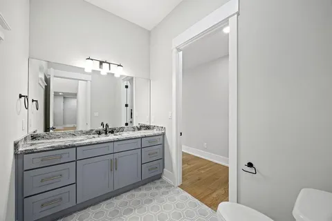 a bathroom with a granite countertop sink toilet a large mirror a vanity and shower