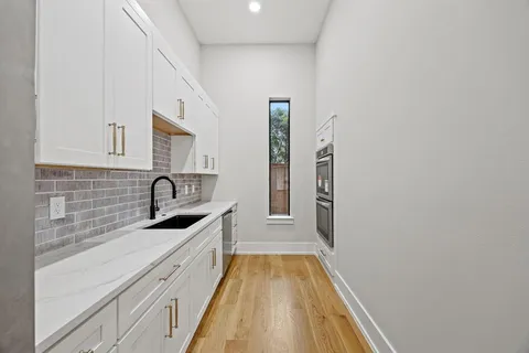 a kitchen with granite countertop white cabinets and stainless steel appliances
