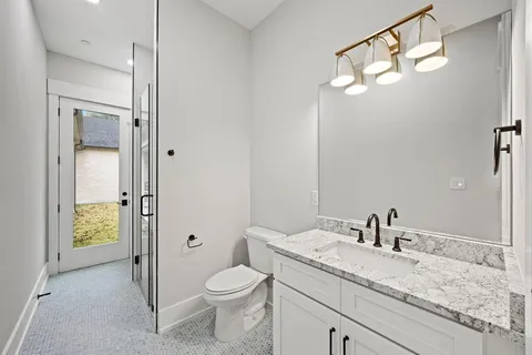 a bathroom with a granite countertop sink toilet and shower