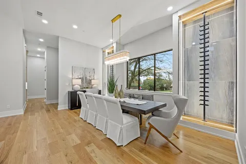 a dining room with furniture a chandelier and wooden floor