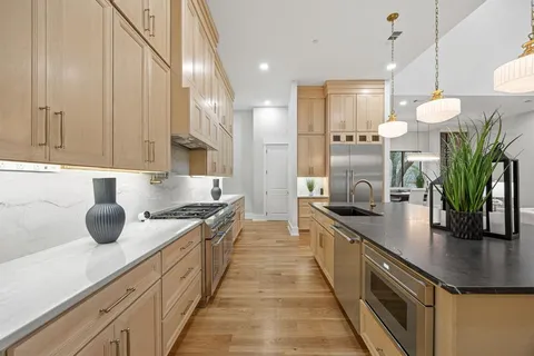 a kitchen with stainless steel appliances a sink a counter top space cabinets and a potted plant