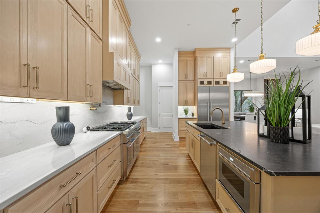 4208 Allencrest Lane Dallas, TX 75244 - Photo 9 of 40 a kitchen with stainless steel appliances a sink a counter top space cabinets and a potted plant