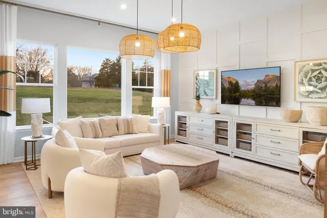 a living room with furniture a flat screen tv and floor to ceiling window