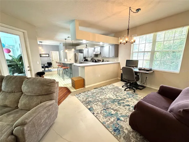 a living room with furniture fireplace and large windows