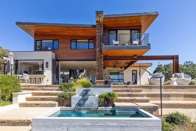 a front view of a house with fountain and entertaining space