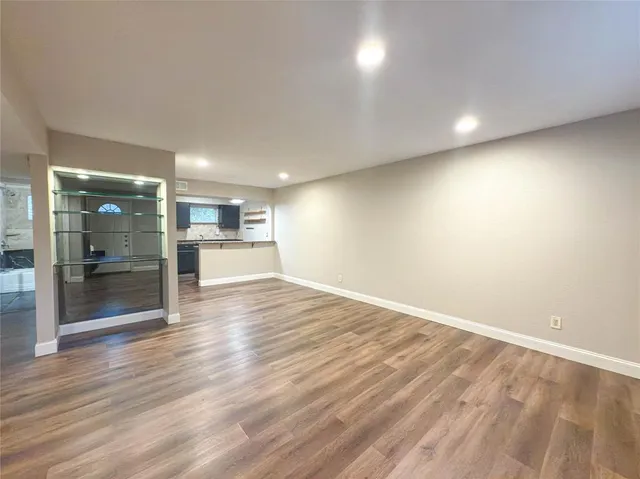 a view of empty room with wooden floor
